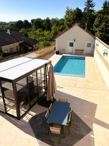 ein Swimmingpool mit einem Tisch und einem Haus in der Unterkunft Jolie maison 6 pers spa privé wifi 14 km Beauval in Meusnes