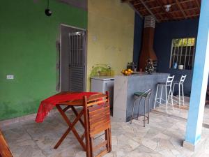a kitchen with a table and a counter in a room at Recanto Barcelos de Mel com piscina e churrasqueira in Camamu +6 photos