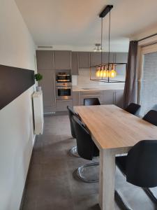 une cuisine avec une table en bois et des chaises noires dans l'établissement Ruim appartement met terras, à Gand