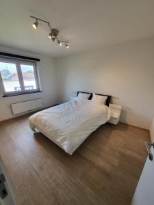 une chambre avec un lit blanc et une fenêtre dans l'établissement Ruim appartement met terras, à Gand