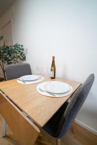 einen Holztisch mit zwei Gläsern und einer Flasche Wein in der Unterkunft Modern Studio in the Heart of Linné, Walk to Haga in Göteborg