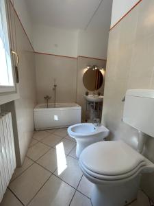 a bathroom with a toilet and a sink and a tub at Il Centro Apartments 2 in Salsomaggiore Terme +6 photos