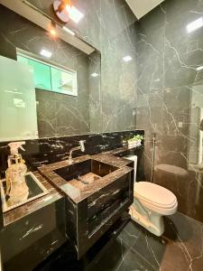 ein Badezimmer mit Waschbecken und Toilette in der Unterkunft Casa Luxo, 3 Qt, Piscina, 2 Vaga, e Área Gourmet in Palmas
