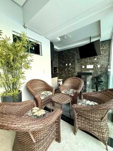 eine Lobby mit Korbstühlen und einem Kamin in der Unterkunft Casa Luxo, 3 Qt, Piscina, 2 Vaga, e Área Gourmet in Palmas
