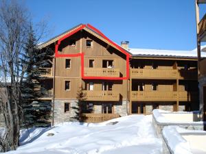 un grand bâtiment avec de la neige devant lui dans l'établissement Appartement Les Airelles, à Levassaix 2 autres photos
