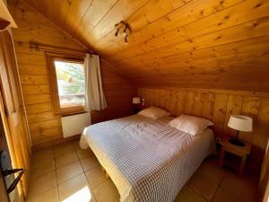 une chambre avec un lit dans une cabane en bois dans l'établissement Appartement Les Airelles, à Levassaix