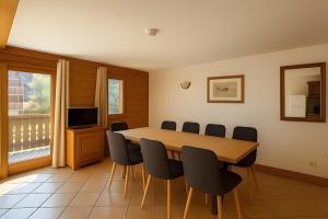 une salle de conférence avec une table et des chaises en bois dans l'établissement Appartement Les Airelles, à Levassaix