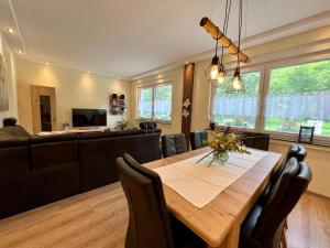 a dining room with a table and a couch at Suite Am Radweg in Pittenbach