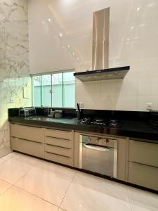 eine Küche mit Spüle und Herd oberen Backofen in der Unterkunft Casa Luxo, 3 Qt, Piscina, 2 Vaga, e Área Gourmet in Palmas