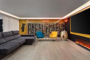 a living room with a couch and chairs and a tv at Porta 30 in Oeiras