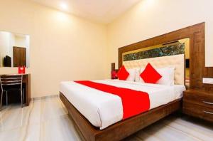 une chambre avec un grand lit avec des oreillers rouges dans l'établissement Marquis Beach Resort, à Candolim