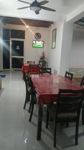 a dining room with a red table and chairs at White House Galaha in Galaha Town +4 photos