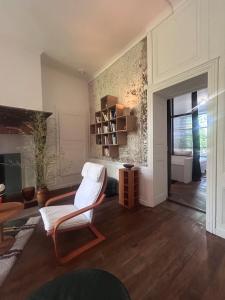 Una sala de estar con una silla y una estantería. en la maison des dames,  18 fotos más