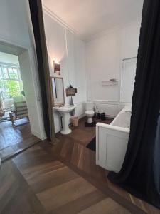 a white bathroom with a tub and a sink at la maison des dames in Poussay +18 photos