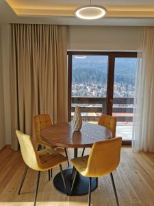 ein Esszimmer mit Tisch und Stühlen und einem Fenster in der Unterkunft Pensiunea Leonida - RESORT LEONIDA in Poiana Ţapului