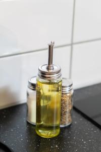 ein Glas Öl und drei Gläser Gewürze in der Unterkunft Warm Modern Studio in the Heart of Linné & Haga in Göteborg