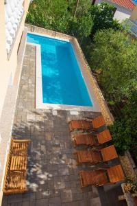 ein Schwimmbad mit einem Haufen Stühle daneben in der Unterkunft Studio für 2 Personen  1 Kind ca 40 qm in Šilo, Kvarner Bucht Krk in Šilo