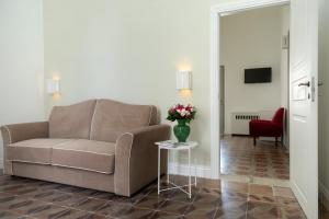 a living room with a couch and a table with flowers at Relais San Martino - Salento in Taviano