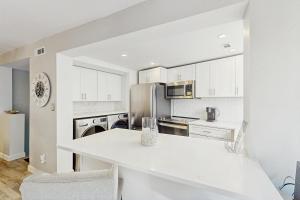 eine Küche mit weißen Schränken und einer weißen Arbeitsplatte in der Unterkunft Seascape Villas 3040 in Hilton Head Island