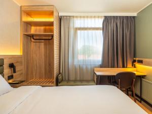 a hotel room with a bed and a desk at Campanile Hotel & Restaurant Breda in Breda +37 photos