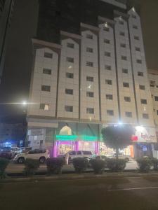ein großes Gebäude, vor dem Autos parken in der Unterkunft فندق مسار الأمل الذهبي - أثمان سابقاً in Al ‘Azīzīyah