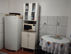 a small kitchen with a microwave and a table at Espaço Ideal 2 in Cascavel