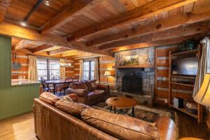 a living room with leather furniture and a fireplace at A River Runs Through It in Valle Crucis