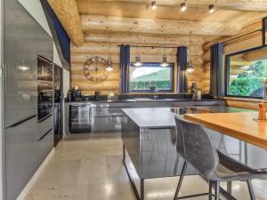 a kitchen with stainless steel appliances and a wooden ceiling at Ferienblockhaus Schwarzwald - Luxus Chalet mit Sauna & Whirlpool in Feldberg