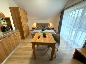 a room with a bed and a table and a kitchen at Hídfő Apartman in Gyula +26 photos