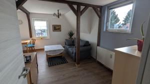 a living room with a couch and a chair at Ruhiges Dachgeschoss-Apartment im Südosten von Dresden in Dresden