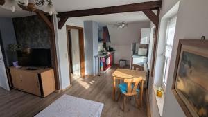 a living room with a dining room table and a television at Ruhiges Dachgeschoss-Apartment im Südosten von Dresden in Dresden