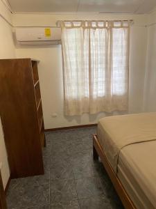 a bedroom with a bed and a dresser and a window at Maudie in Santa Teresa Beach