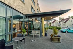 un edificio con un banco y una mesa delante de él en Zefyr Hotel, en Bodø