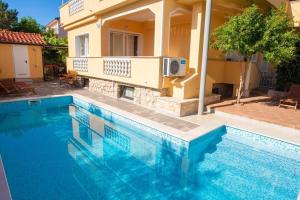 ein Swimmingpool vor einem Haus in der Unterkunft Studio für 2 Personen  2 Kinder ca 60 qm in Šilo, Kvarner Bucht Krk in Šilo