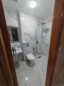 Un baño blanco con inodoro y lavabo. en Appartement idéal à El Jadida pour les familles, en Sidi Bouzid