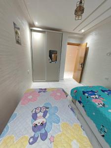 Un dormitorio con una cama con una alfombra de Hello Kitty encima. en Appartement idéal à El Jadida pour les familles, en Sidi Bouzid
