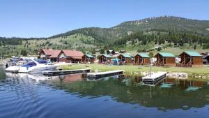 a marina with a bunch of houses and a boat on the water at Beautiful Lakefront Cabin with Stunning Sights in Montana in Lakeview