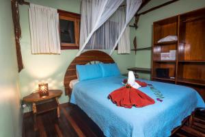 Un dormitorio con una cama con un vestido rojo encima. en Samara Treehouse Inn Unit 3, en Sámara