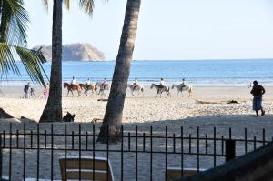 - un groupe de personnes à cheval sur la plage dans l'établissement Samara Tree House Inn Unit 4, à Sámara