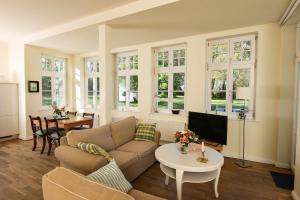 a living room with a couch and a table at Wohnung Im Ersten Obergeschoss Des Gutshauses in Neuenkirchen