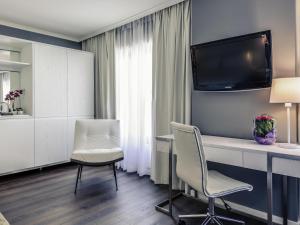 a room with a desk and two chairs and a tv at Mercure Hotel Raphael Wien in Vienna +58 photos