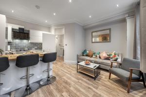 a kitchen and a living room with a couch at Zone 2 Luxury 3Bed 2Bath Apt - Kilburn in London