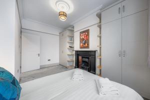 a bedroom with a bed and a fireplace at Zone 2 Luxury 3Bed 2Bath Apt - Kilburn in London
