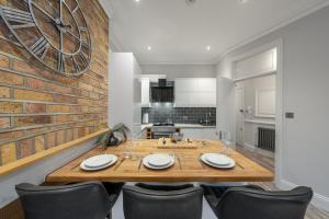 a dining room with a wooden table and chairs at Zone 2 Luxury 3Bed 2Bath Apt - Kilburn in London +14 photos