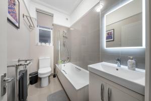 a white bathroom with a sink and a toilet at Zone 2 Luxury 3Bed 2Bath Apt - Kilburn in London