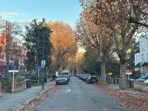 a street with cars parked on the side of the road at Zone 2 Luxury 3Bed 2Bath Apt - Kilburn in London