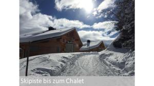 a snow covered house with the sun in the sky at Panorama 2 Bett Wohnung in Mürren +13 photos