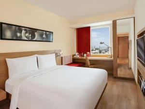 a bedroom with a large white bed and a window at ibis Kochi City Centre - An Accor Brand in Cochin +73 photos