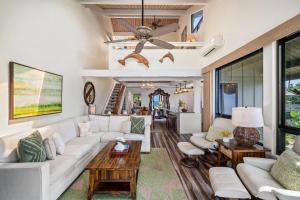 a living room with a white couch and a ceiling fan at Kahana Village 20 in Kahana