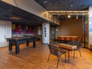 a room with a ping pong table and chairs at ibis budget Jundiai Shopping in Jundiaí